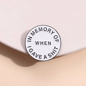 Macro shot of round enamel lapel pin with funny quote in memory of when I gave a shit