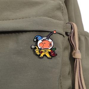 Close-up of colorful Pikmin enamel pins attached to a green canvas backpack pocket