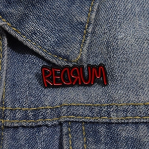 Creative Redrum enamel metal pin with bloody lettering on denim jacket accessory