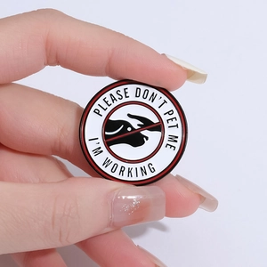Round enamel working dog pin featuring 'PLEASE DON'T PET ME I'M WORKING' warning sign