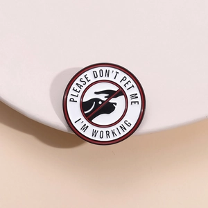 Close-up of circular enamel pin featuring Please Don't Pet Me I'm Working text