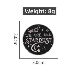 Black round enamel pin badge with silver We Are All Stardust lettering and stars, 3.0cm size