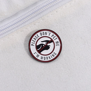 Round enamel pin with 'PLEASE DON'T PET ME I'M WORKING' text and service dog icon