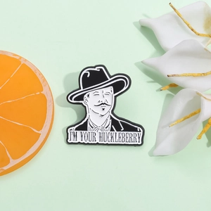 Enamel pin featuring a cowboy and I'M YOUR HUCKLEBERRY text in black and white