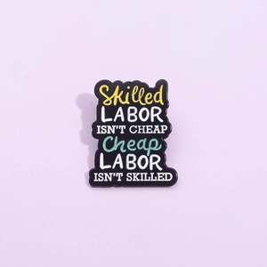 Broche créative en émail noir avec une typographie colorée sur un badge métallique chic