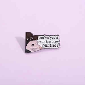 Cartoon opossum cowboy enamel pin with humorous text on a soft purple background