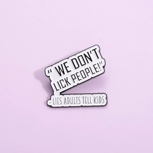 Détail macro d'un pin's émaillé avec la phrase humoristique We Don't Lick People