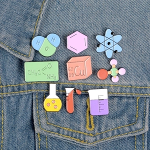 Detailed set of nine science-themed enamel pins featuring lab glassware and molecules