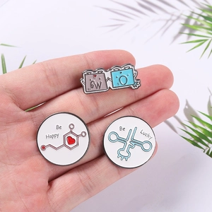 Detailed close-up of science enamel pins featuring chemical formulas and lucky slogans
