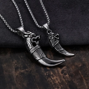 Macro shot of stainless steel tribal tiger tooth pendants with intricate wolf head carvings