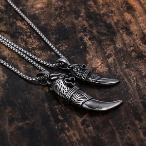 Macro detail of vintage tiger tooth wolf pendants on rustic wood background