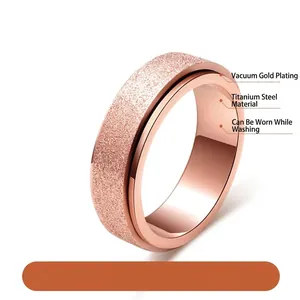 Dettaglio di anello in acciaio al titanio oro rosa con finitura satinata e fascia rotante