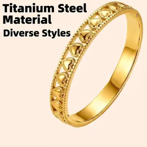 Modern gold titanium steel hinged bangle featuring a continuous hollow heart pattern