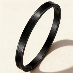 Détail d'un bracelet jonc de 6 mm en acier inoxydable noir brossé au design minimaliste.