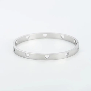Detalle de un brazalete de acero inoxidable con delicados diseños de corazones calados
