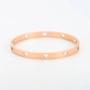 Detalle de brazalete de acero inoxidable en oro rosa con elegantes corazones calados