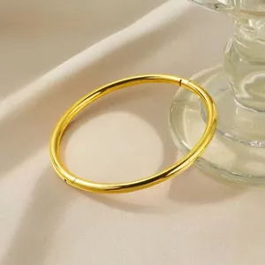 Minimalistischer Armreif aus 18 Karat vergoldetem Edelstahl mit glattem Finish und Verschluss.