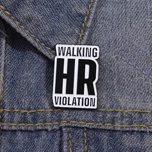 Detailed shot of enamel pin with Walking HR Violation text on denim fabric