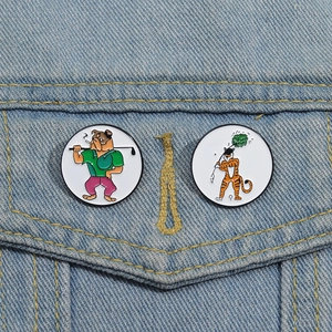 Detail of golf bulldog and tiger enamel pins on light blue denim jacket pockets