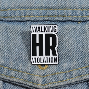 Cartoon enamel pin with Walking HR Violation text on a blue denim jacket pocket