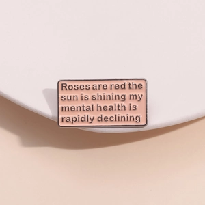 Detail shot of rectangular pink enamel pin with black humorous metal health quote text