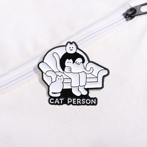 Cartoon enamel pin featuring a person with cats and 'CAT PERSON' text on a canvas bag
