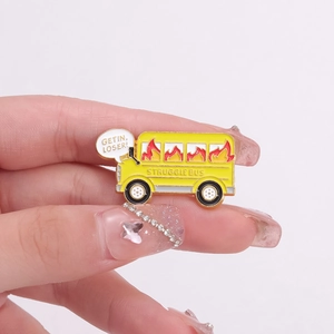 Hand holding Struggle Bus enamel pin with Get in Loser text on a yellow bus design