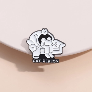 Detail of CAT PERSON enamel pin featuring cat lover illustration on a stylish cream stand
