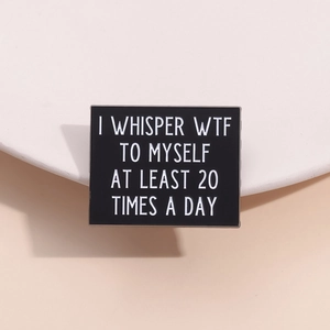 Black square enamel pin with witty white text on a minimalist ceramic pedestal
