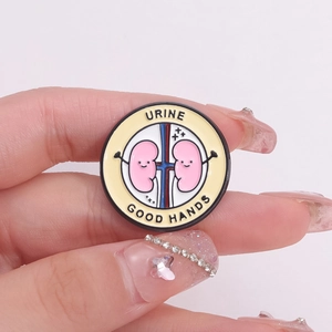 Spilla smaltata a forma di rene cartoon con testo Urine Good Hands e design medico