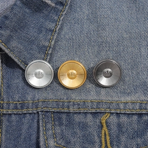 Three-color round metal buttons with emblem on blue denim, gold silver gun-grey