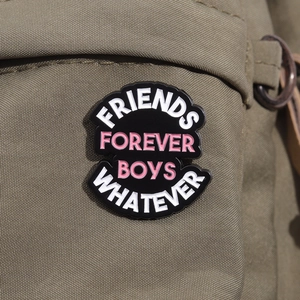Close-up of enamel pin with Friends Forever Boys Whatever text on a canvas bag
