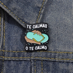 Lustiger Flip-Flop Emaille-Pin mit Spruch TE CALMAS O TE CALMO auf Jeansjacke