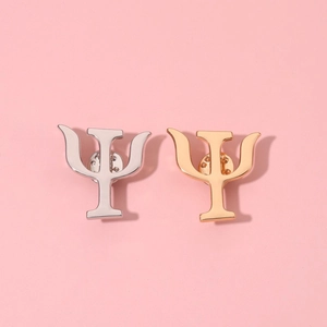 Broches symbole Psi polies en or et argent avec fermoir papillon sur fond rose