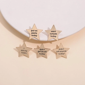 Set aus fünf goldenen Emaille-Stern-Pins mit Text auf minimalistischem beigem Hintergrund