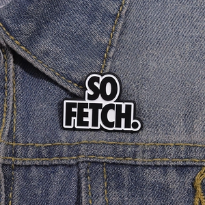 Minimalist 'SO FETCH.' letter enamel brooch pinned on a blue denim jacket collar
