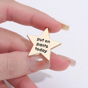 Sternförmige goldene Emaille-Brosche aus Metall mit dem lustigen Spruch Put On Pants Today