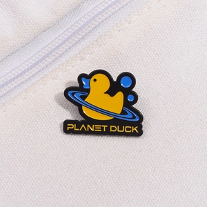 Détail d'un pin's en émail représentant un canard jaune avec un anneau étoilé bleu