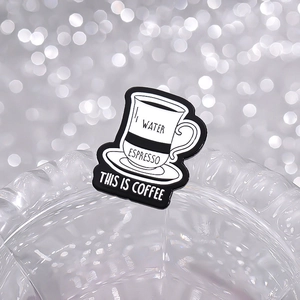 Macro view of coffee cup enamel pin with ESPRESSO and THIS IS COFFEE engraving