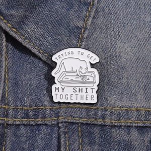 Épinglette humoristique chat et litière avec texte sur veste en jean bleue
