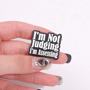 Broche en émail noir et blanc avec citation humoristique I'm Not Judging I'm Assessing