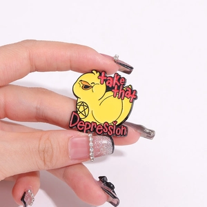 Detailed view of yellow duck enamel pin with take that Depression motivational text