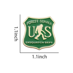 Detailed 1.1 inch forest green enamel Sasquatch shield pin with gold metallic edges