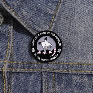 Funny cartoon opossum enamel pin badge on a denim jacket showing a humorous quote