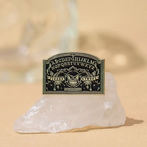 Gothic vampire cat Ouija board enamel pin with gold lettering and alphabet design