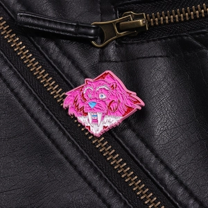 Detail of pink cartoon enamel pin with sharp teeth on a black leather jacket lapel