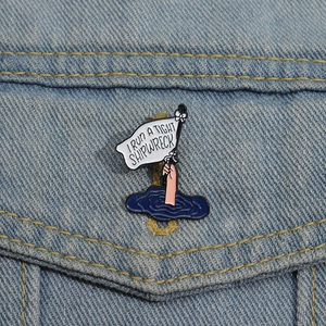 Creative enamel pin with I RUN A TIGHT SHIPWRECK slogan on blue denim jacket pocket