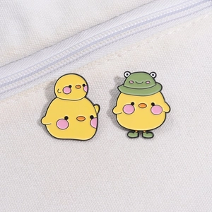 Broches en émail de canard jaune mignon avec deux modèles sur fond de toile blanche