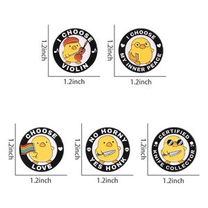 Detail showing five assorted 1.2-inch cartoon yellow duck enamel pins with music and art motifs