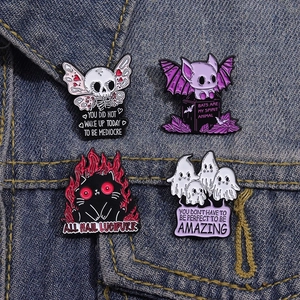 Gothic ghost and black cat enamel pin set displayed on blue denim jacket material